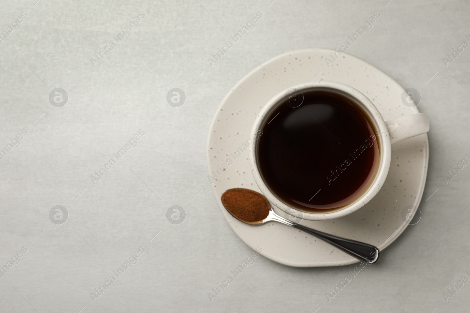 Cup of delicious chicory drink and spoon with powder on light grey table, top view. Space for text Photo of Cup of delicious chicory drink and spoon with powder on light grey table, top view. Space for text