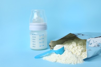 Bag of powdered infant formula, feeding bottle and scoop on light blue background, space for text. Baby milk Photo of Bag of powdered infant formula, feeding bottle and scoop on light blue background, space for text. Baby milk