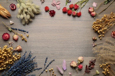 Frame of different dry flowers on wooden background, flat lay. Space for text Photo of Frame of different dry flowers on wooden background, flat lay. Space for text