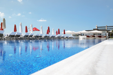 Outdoor swimming pool at sea resort on sunny day Photo of Outdoor swimming pool at sea resort on sunny day