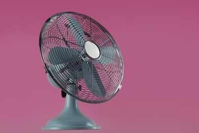 Modern electric fan on pink background. Space for text Photo of Modern electric fan on pink background. Space for text