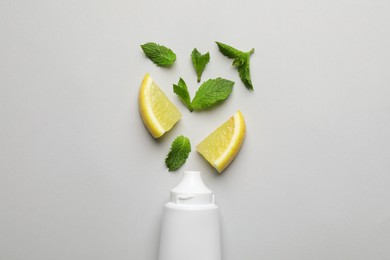 Blank tube of toothpaste with mint and lemon on white background, flat lay Photo of Blank tube of toothpaste with mint and lemon on white background, flat lay