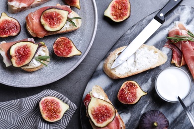Sandwiches with ripe figs, cream cheese and prosciutto served on black table, flat lay Photo of Sandwiches with ripe figs, cream cheese and prosciutto served on black table, flat lay