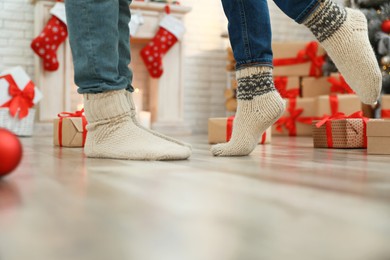 Couple in warm socks in room decorated for Christmas, closeup Image of Couple in warm socks in room decorated for Christmas, closeup