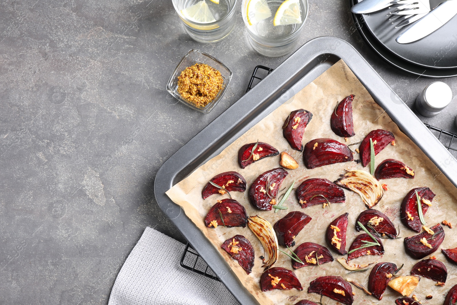 Baking tray with roasted beetroot slices on grey table, flat lay Photo of Baking tray with roasted beetroot slices on grey table, flat lay