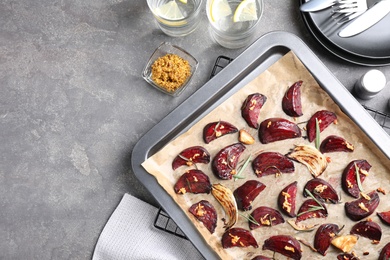 Baking tray with roasted beetroot slices on grey table, flat lay Photo of Baking tray with roasted beetroot slices on grey table, flat lay