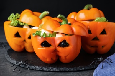 Bell peppers with black olives, mozzarella and lettuce as Halloween monsters on dark table, closeup Photo of Bell peppers with black olives, mozzarella and lettuce as Halloween monsters on dark table, closeup