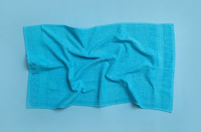 Crumpled soft beach towel on light blue background, top view Photo of Crumpled soft beach towel on light blue background, top view