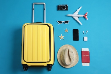Flat lay composition with suitcase and travel accessories on light blue background. Summer vacation Photo of Flat lay composition with suitcase and travel accessories on light blue background. Summer vacation
