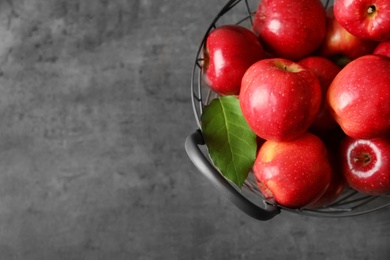 Basket with fresh ripe red apples on grey background Photo of Basket with fresh ripe red apples on grey background