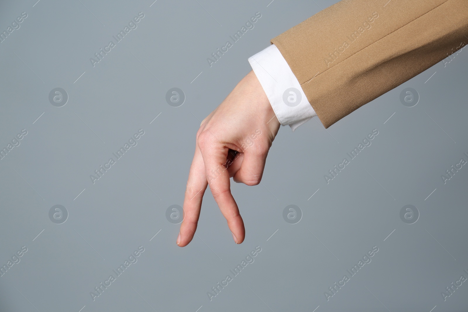 Businesswoman imitating walk with hand on grey background, closeup. Finger gesture Photo of Businesswoman imitating walk with hand on grey background, closeup. Finger gesture