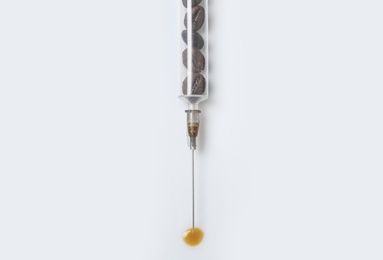 Syringe full of coffee beans on white background, top view. Caffeine addiction concept Photo of Syringe full of coffee beans on white background, top view. Caffeine addiction concept