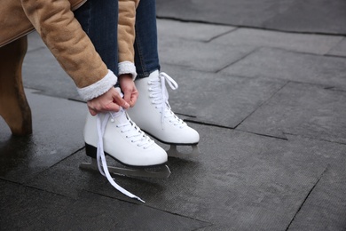 Woman lacing figure skate outdoors, closeup. Space for text Photo of Woman lacing figure skate outdoors, closeup. Space for text