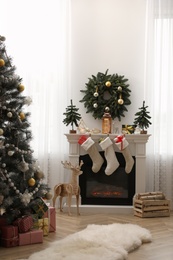 Fireplace in room with Christmas decorations. Interior design Photo of Fireplace in room with Christmas decorations. Interior design