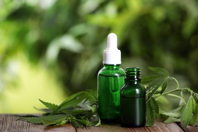 Hemp leaves, bottles of CBD oil and THC tincture on wooden table. Space for text Photo of Hemp leaves, bottles of CBD oil and THC tincture on wooden table. Space for text