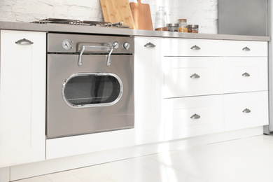 Photo of New modern oven in stylish kitchen. Cooking appliance
