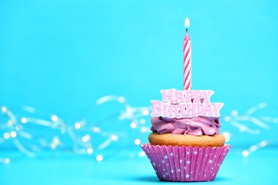 Birthday cupcake with candle on color background Photo of Birthday cupcake with candle on color background