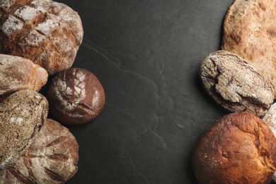 Different kinds of delicious bread on black table, flat lay. Space for text Photo of Different kinds of delicious bread on black table, flat lay. Space for text