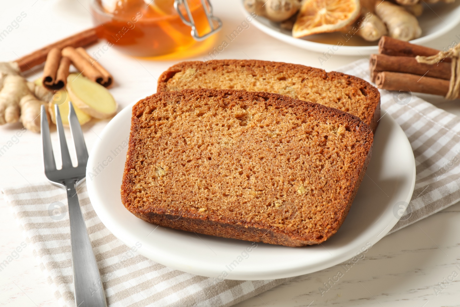 Photo of Fresh gingerbread cake slices served on white wooden table, closeup