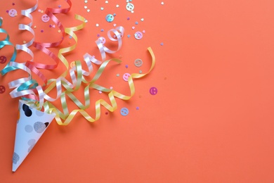 Colorful confetti and streamers with party cracker on orange background, top view. Space for text Photo of Colorful confetti and streamers with party cracker on orange background, top view. Space for text