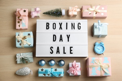 Flat lay composition with Boxing Day Sale sign and Christmas gifts on wooden table Photo of Flat lay composition with Boxing Day Sale sign and Christmas gifts on wooden table