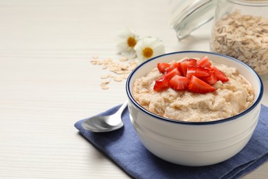 Tasty oatmeal porridge with strawberries served on white wooden table. Space for text Photo of Tasty oatmeal porridge with strawberries served on white wooden table. Space for text