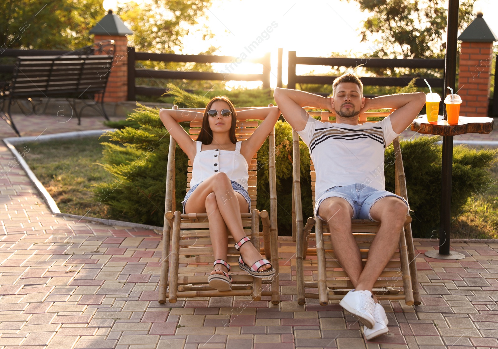 Couple resting together in deck chairs outdoors Image of Couple resting together in deck chairs outdoors