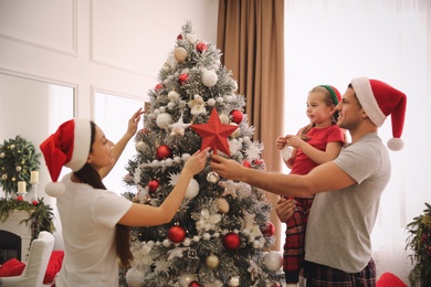 Family decorating Christmas tree with star topper indoors Photo of Family decorating Christmas tree with star topper indoors