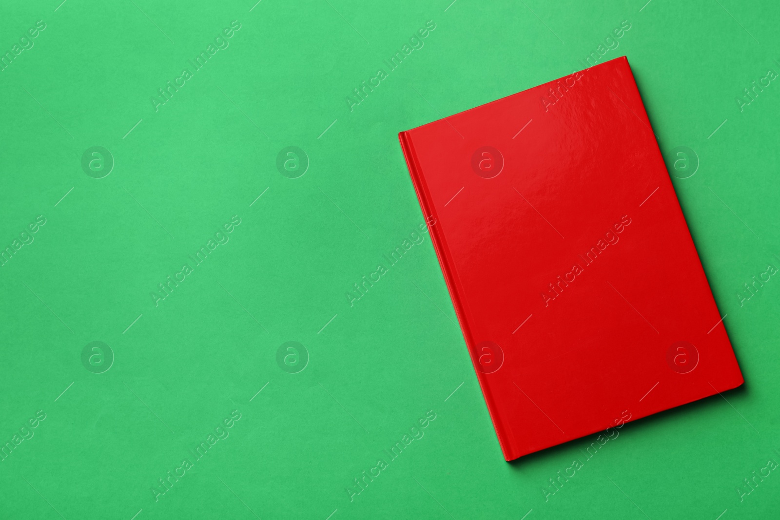 New stylish planner with hard cover on green background, top view. Space for text Photo of New stylish planner with hard cover on green background, top view. Space for text