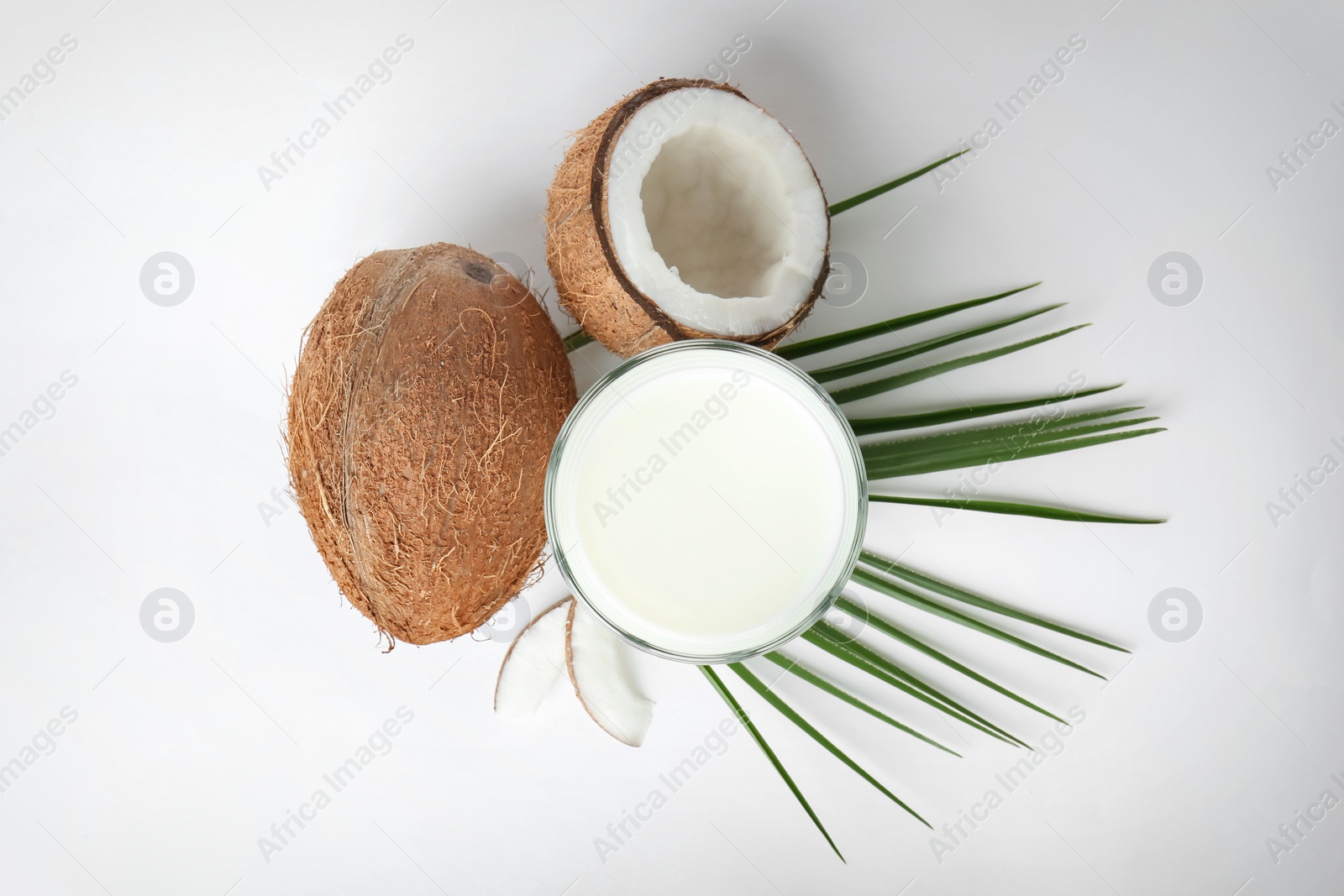 Glass of coconut milk and fresh nuts isolated on white, top view Photo of Glass of coconut milk and fresh nuts isolated on white, top view