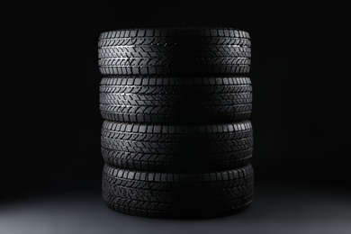Stacked winter tires on black background. Car maintenance Photo of Stacked winter tires on black background. Car maintenance