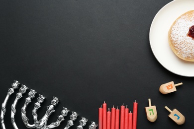 Hanukkah traditional menorah, candles, doughnut and dreidels with letters He, Pe, Nun, Gimel on black background, flat lay. Space for text Photo of Hanukkah traditional menorah, candles, doughnut and dreidels with letters He, Pe, Nun, Gimel on black background, flat lay. Space for text