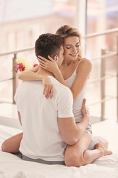 Happy young couple hugging on bed at home Photo of Happy young couple hugging on bed at home