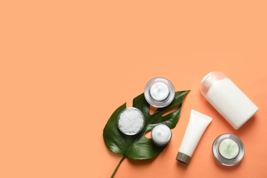 Different skin care cosmetic products with green leaf on color background, top view Photo of Different skin care cosmetic products with green leaf on color background, top view