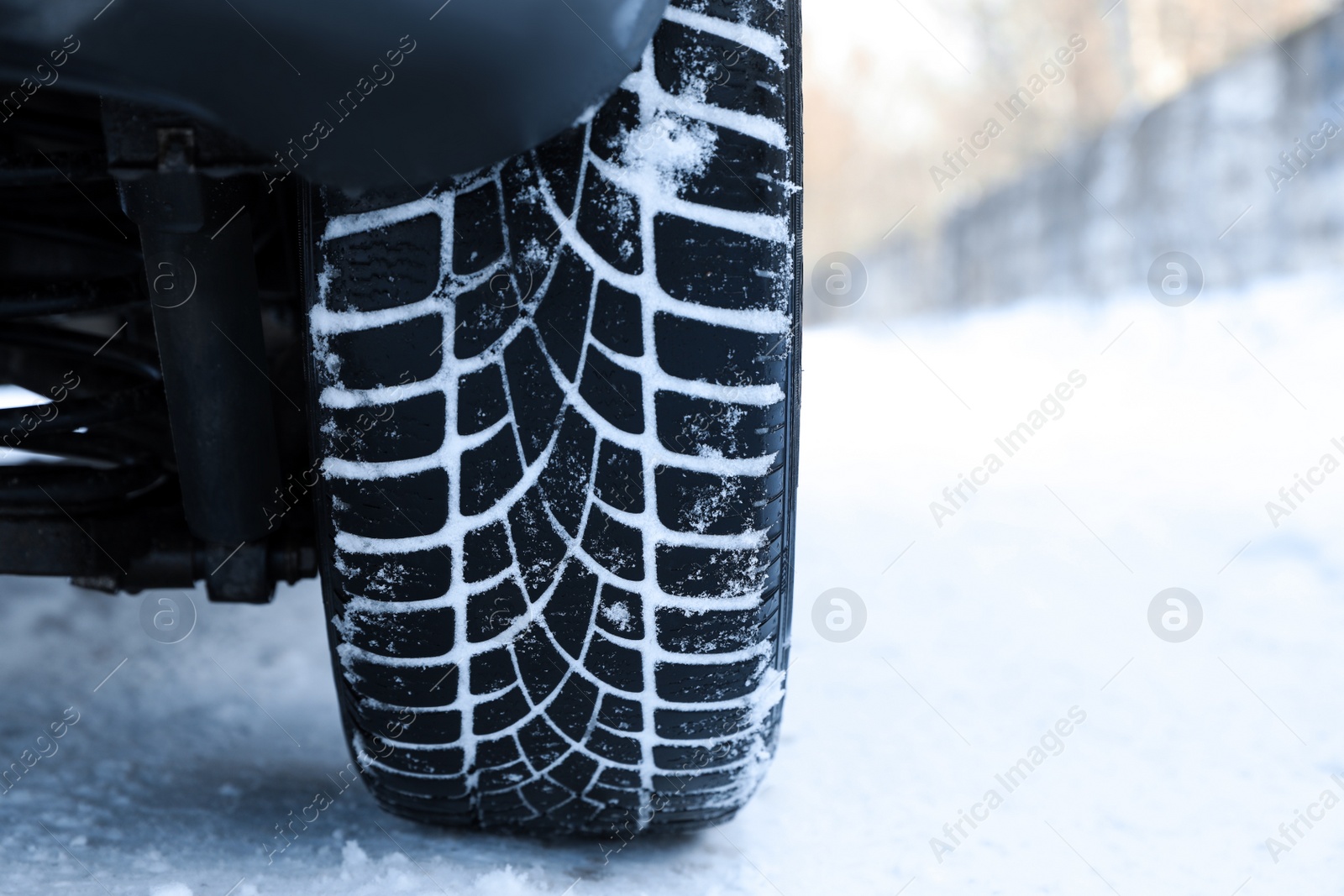 Car with winter tires on snowy road, closeup view Photo of Car with winter tires on snowy road, closeup view