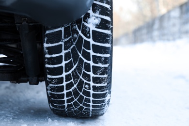 Car with winter tires on snowy road, closeup view Photo of Car with winter tires on snowy road, closeup view