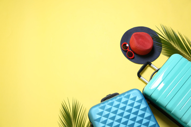Photo of Flat lay composition with suitcases and space for text on yellow background