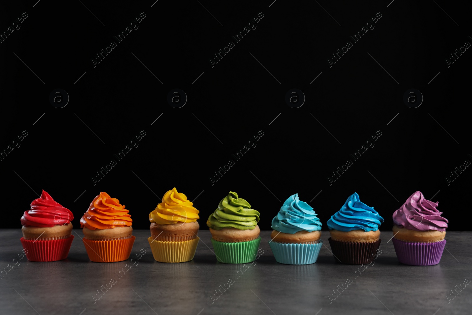 Delicious birthday cupcake on table against black background Photo of Delicious birthday cupcake on table against black background