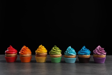 Delicious birthday cupcake on table against black background Photo of Delicious birthday cupcake on table against black background