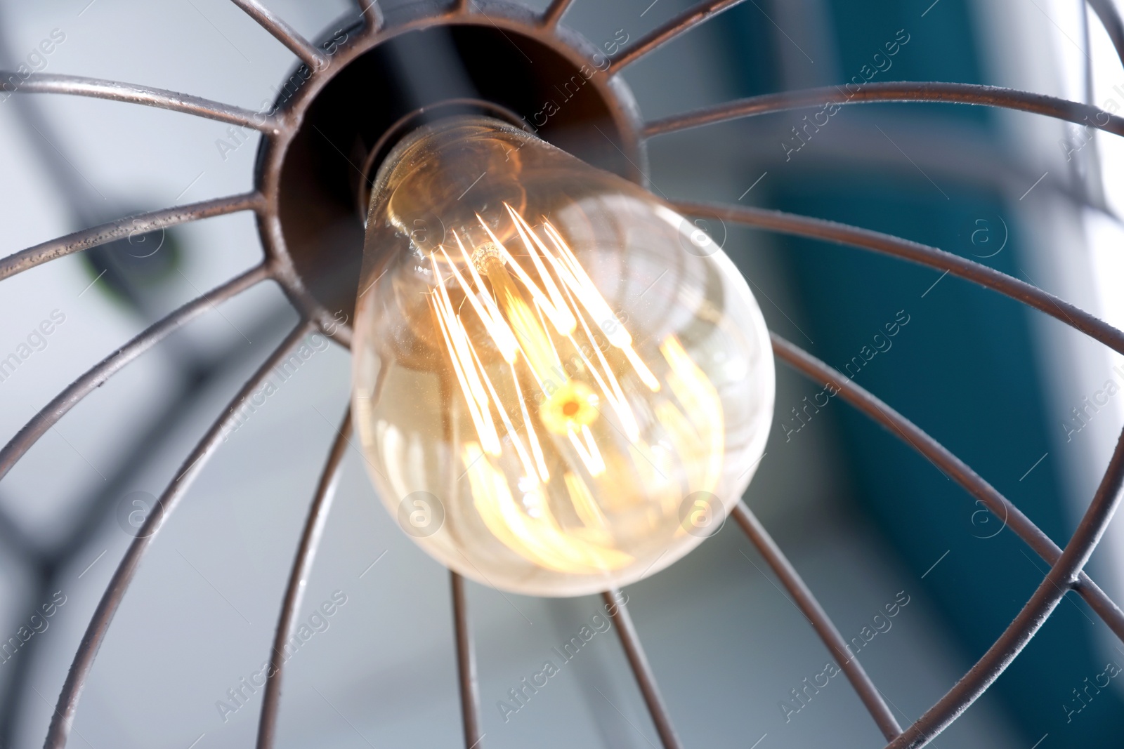 Stylish metallic pendant lamp with Edison light bulb indoors, closeup Image of Stylish metallic pendant lamp with Edison light bulb indoors, closeup
