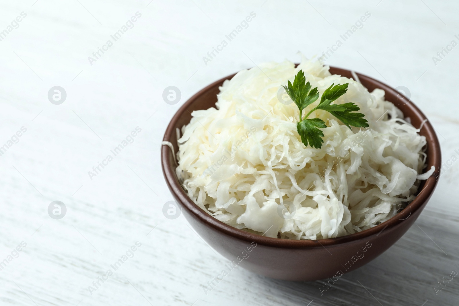 Tasty fermented cabbage on wooden table, closeup Photo of Tasty fermented cabbage on wooden table, closeup