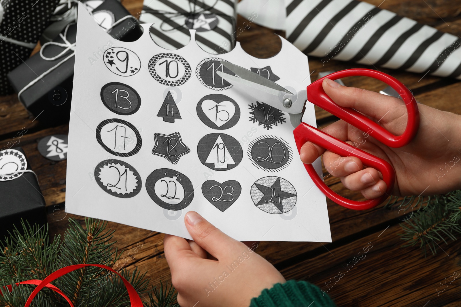 Woman making advent calendar at wooden table, closeup Photo of Woman making advent calendar at wooden table, closeup
