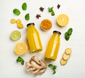 Flat lay composition with immunity boosting drink and ingredients on white wooden table Photo of Flat lay composition with immunity boosting drink and ingredients on white wooden table