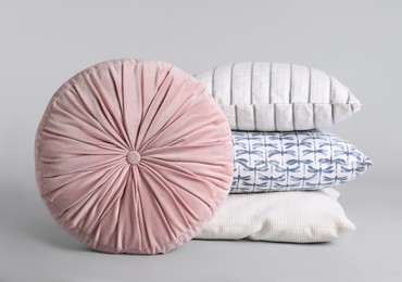 Photo of Different stylish soft pillows on grey background