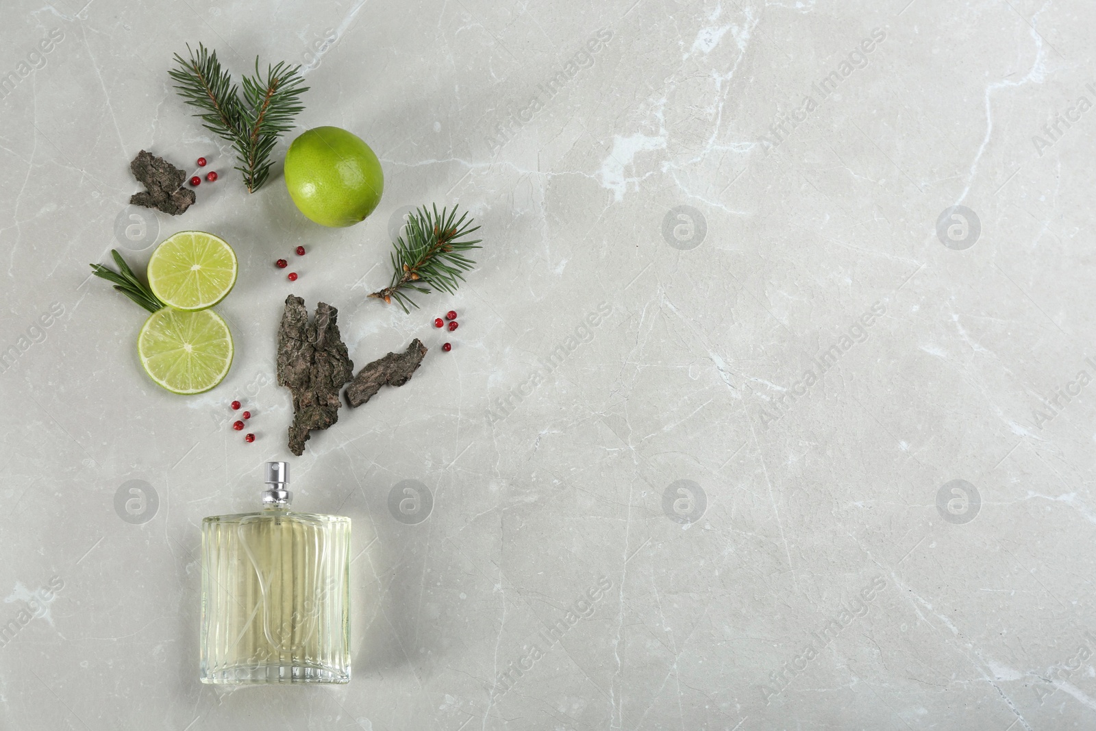 Photo of Flat lay composition with bottle of perfume on marble background, space for text