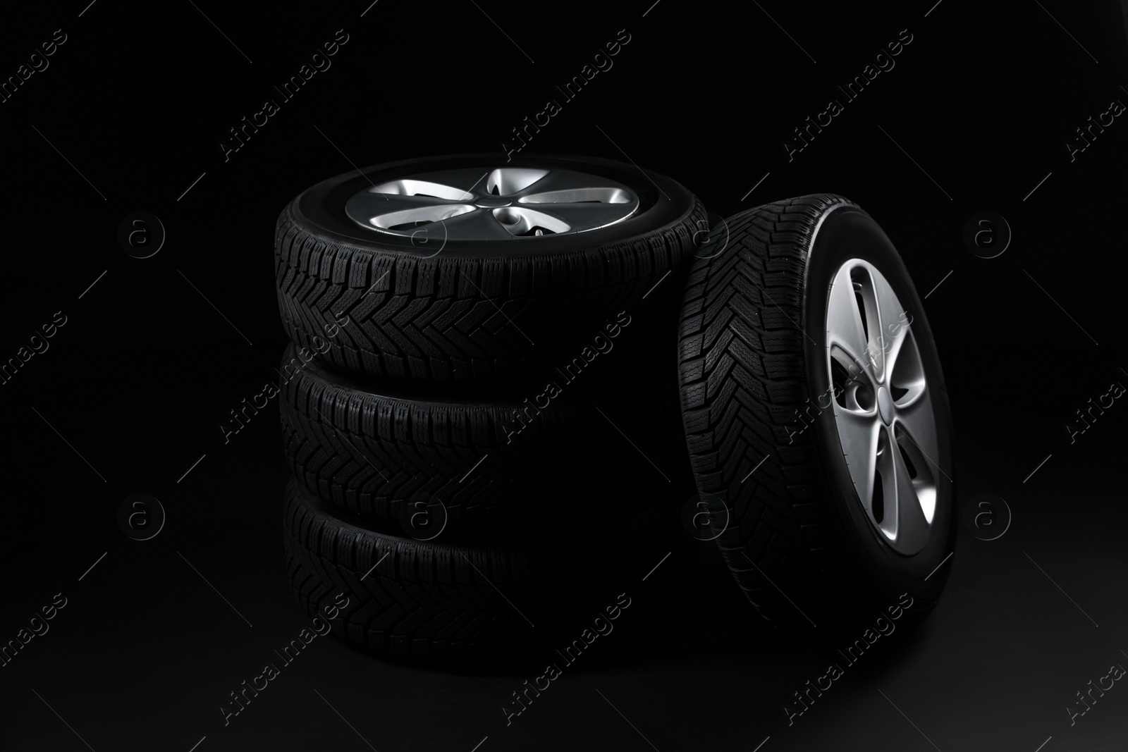Photo of Set of wheels with winter tires on black background