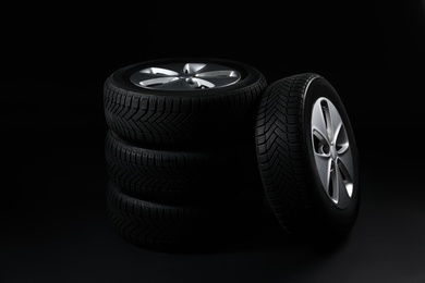 Set of wheels with winter tires on black background Photo of Set of wheels with winter tires on black background