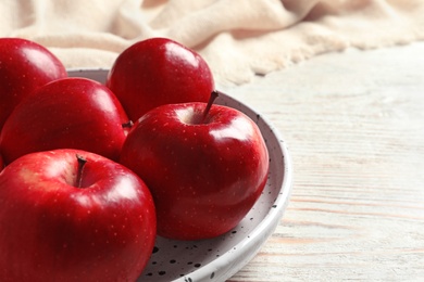Plate with ripe red apples on wooden background Photo of Plate with ripe red apples on wooden background