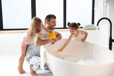 Photo of Young father with little daughters in bathroom