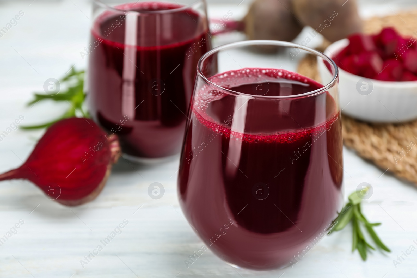 Fresh beet juice and raw vegetable on white table, closeup Photo of Fresh beet juice and raw vegetable on white table, closeup